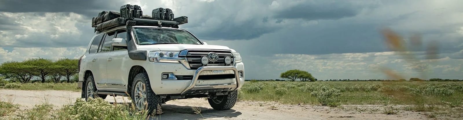 Land Cruiser 200 with a full Front Runner roof rack and cases under a stormy sky