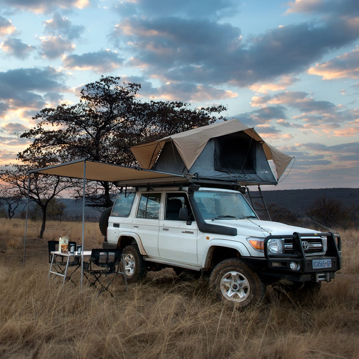 Land Cruiser 76 wagon with a Front Runner rack, rooftop tent and awning at camp in the bushveld
