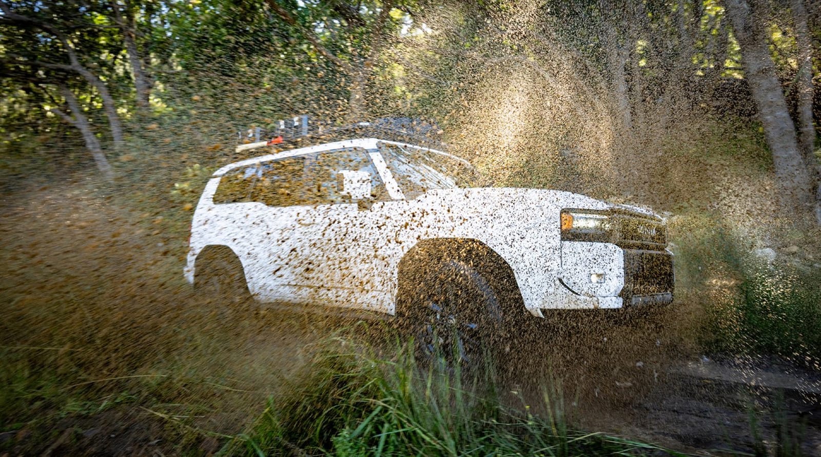 Prado 250 with a roof rack driving through mud