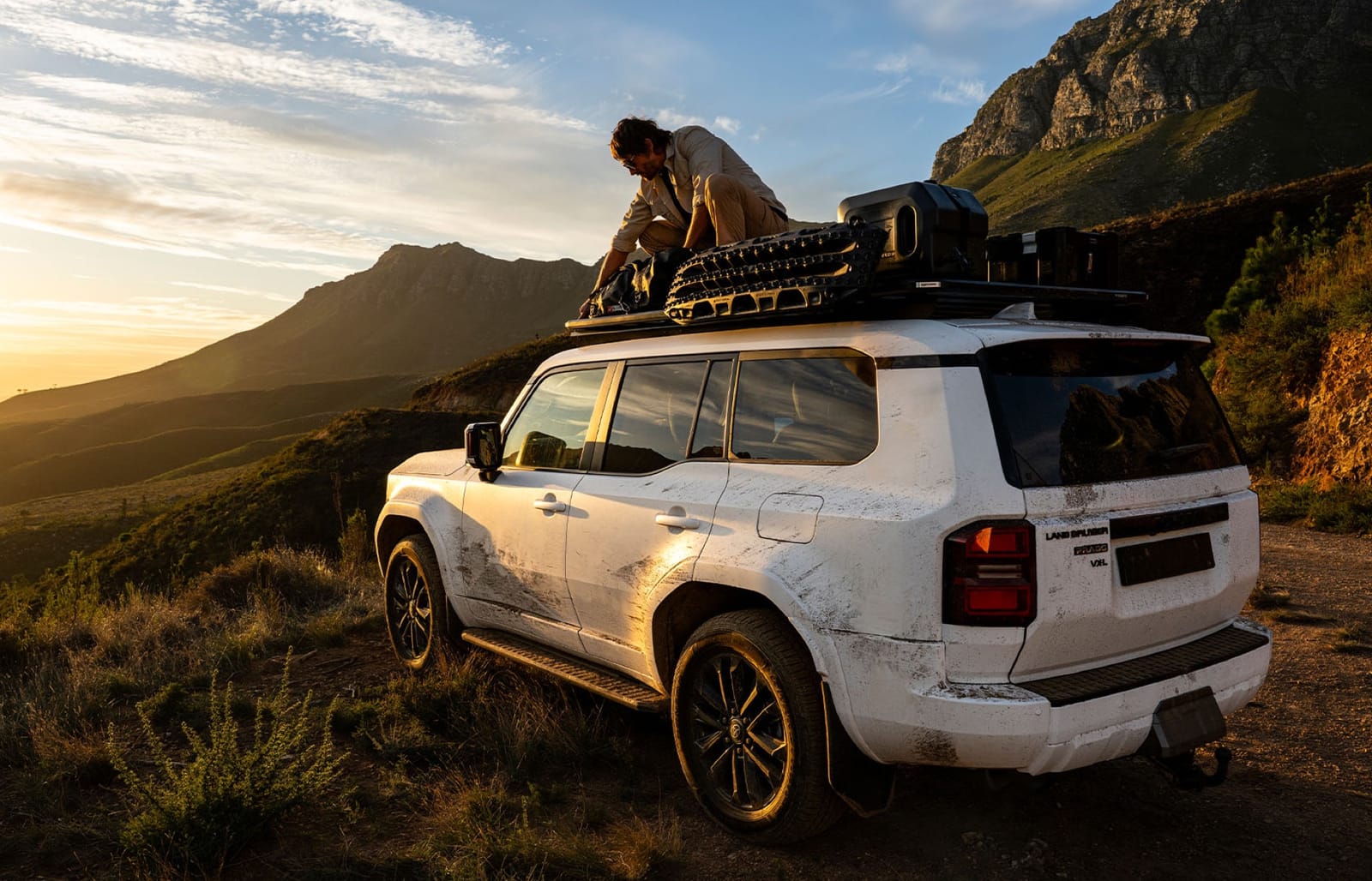 White Land Cruiser Prado 250 with a loaded Slimline 3 roof rack in the mountains at sunset