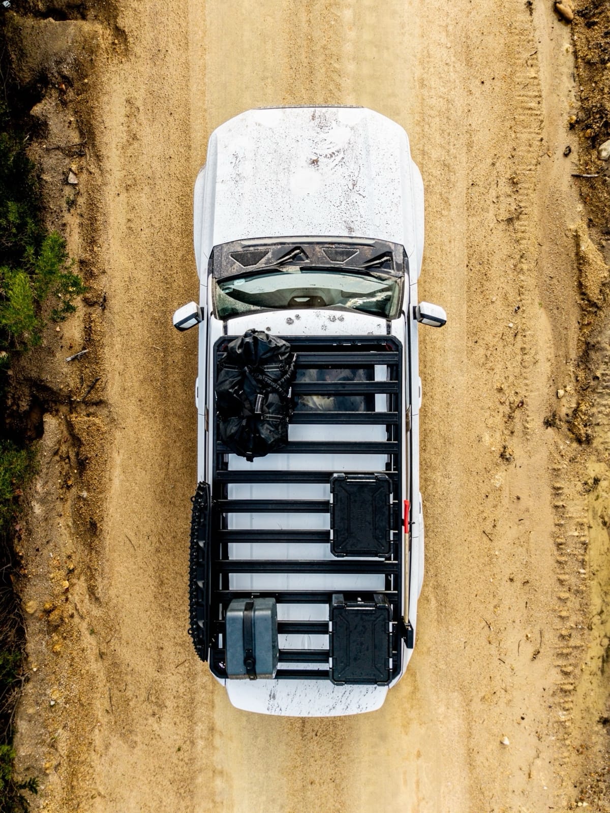 Top-down view of a loaded Slimline 3 roof rack on a gravel road