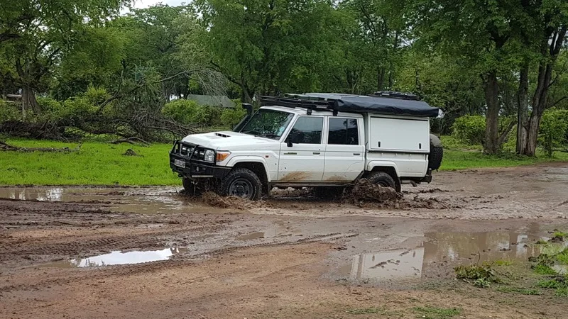 Land Cruiser 79 double cab with canopy driving through mud