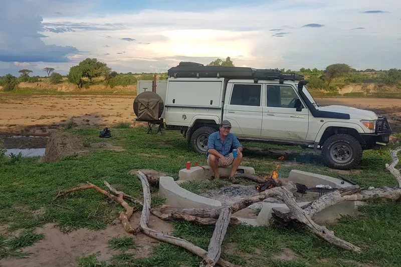 Land Cruiser camp with a fire beside a pan