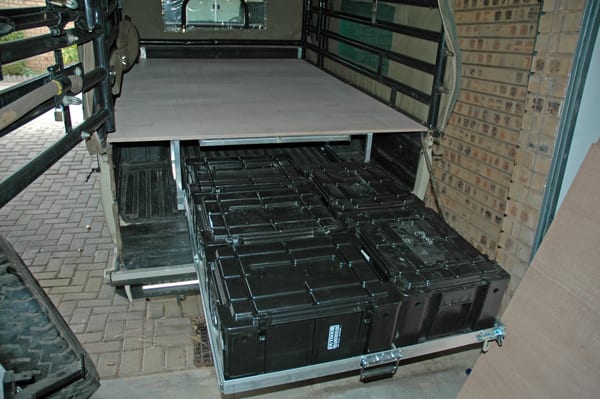 A home-built aluminium drawer system in the canopy of a Land Cruiser 79 bakkie, two drawers pulled out and full of black plastic boxes