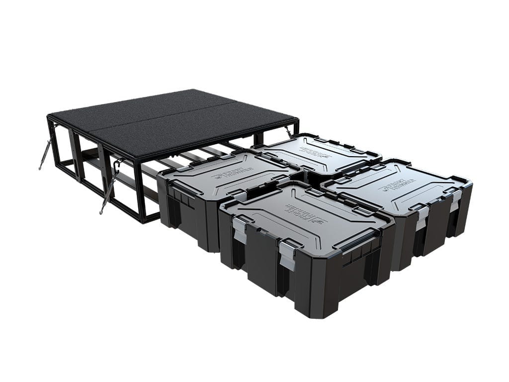A black Front Runner Wolf Pack Pro storage system frame and deck with four Wolf Pack Pro boxes in front of it