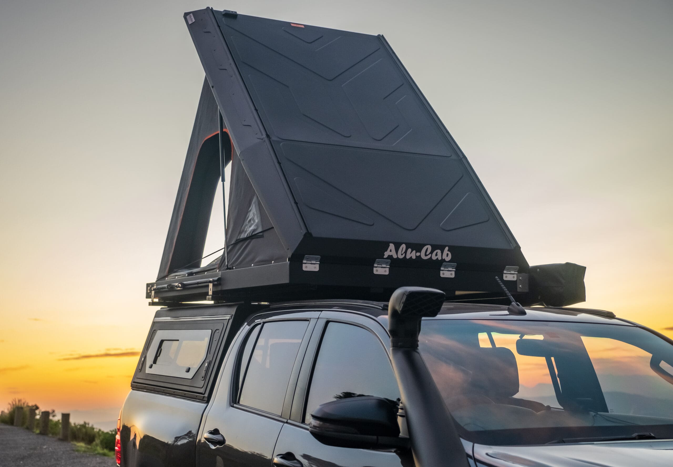 Alu-Cab Gen 3-R hardshell rooftop tent opening at sunset