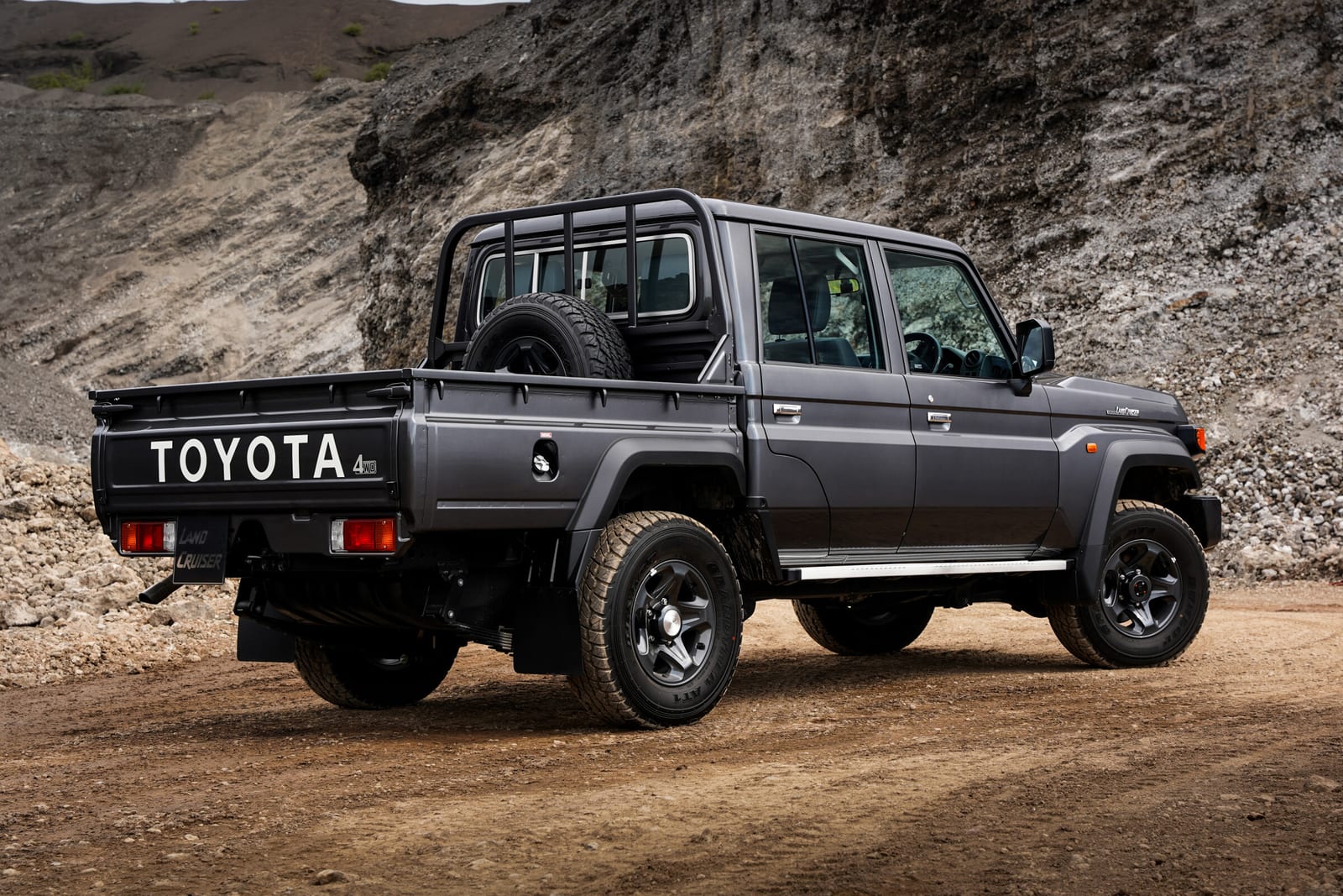 The rear of a grey new-shape Land Cruiser 79 double cab, showing the load bin, rear bumper and tow hitch