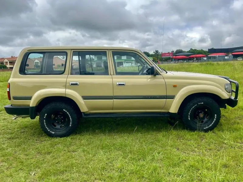 Sand-coloured Toyota Land Cruiser 80 Series in profile on BFGoodrich all-terrain tyres and black rims