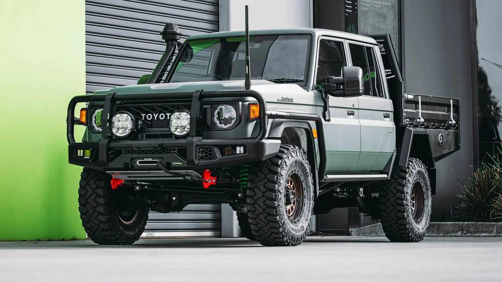 A white new-shape Land Cruiser 79 double cab with a steel bull bar, winch, snorkel, lift and a steel tray with toolboxes