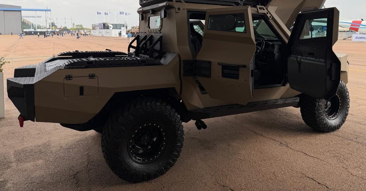 The Milkor Frontier from the rear three-quarter, showing the load bed, open armoured doors and big off-road tyres