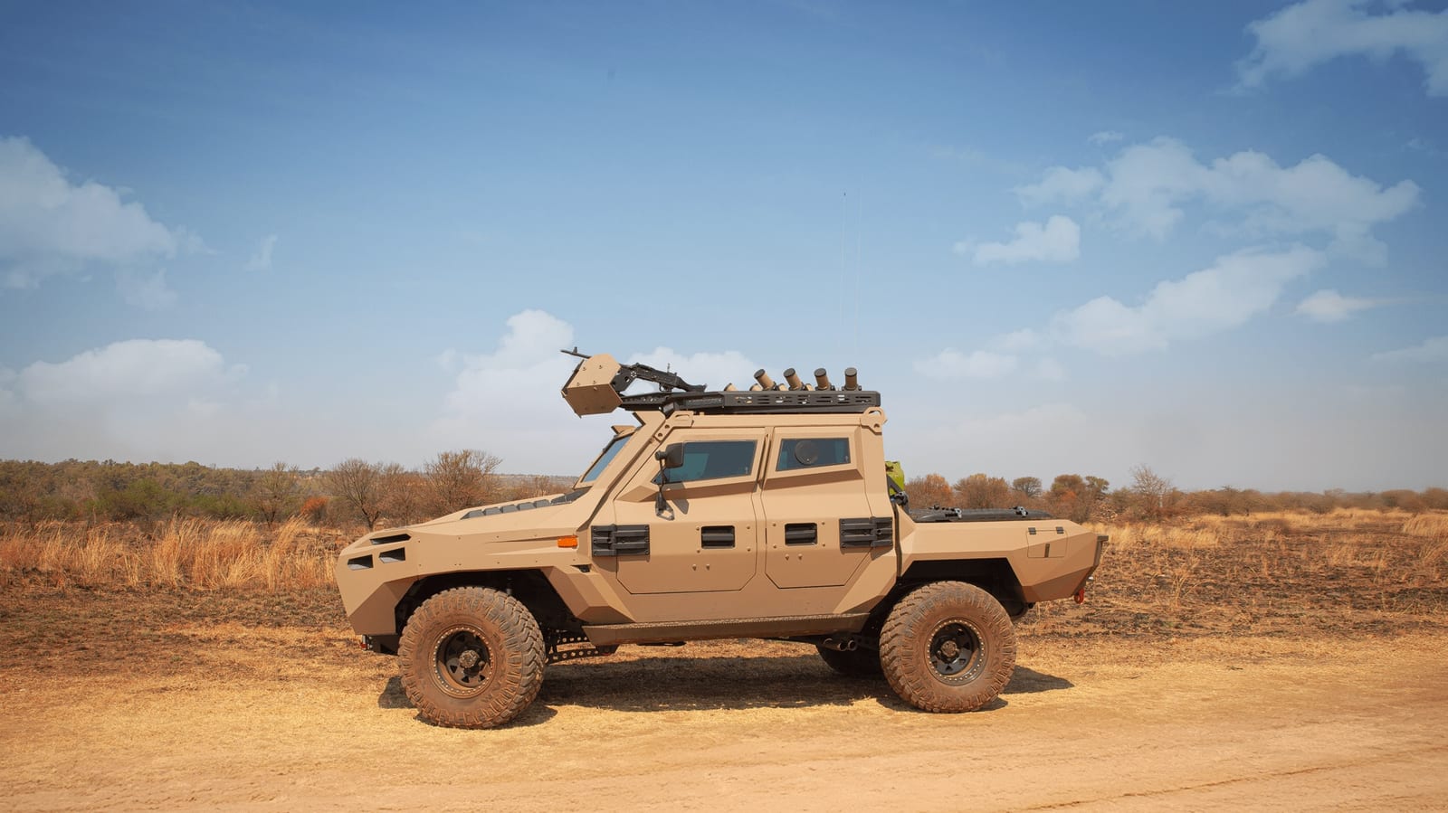 The Milkor Frontier 4x4, an armoured Land Cruiser 79, side-on on a dirt road in dry bushveld.